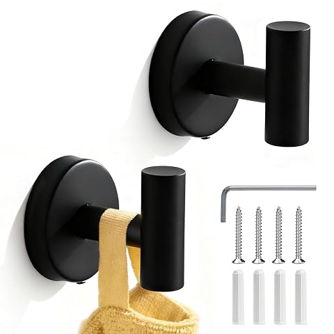 Deux crochets muraux noirs en acier inoxydable, dont un porte une serviette dans une salle de bain claire.