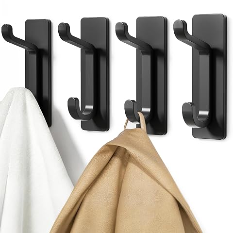 Quatre patères adhésives doubles en aluminium noir alignées sur un mur de salle de bain