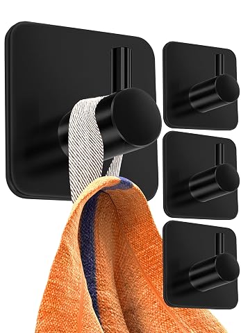 Quatre crochets porte-serviettes noirs adhésifs fixés sur un mur carrelé clair de salle de bain.