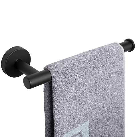 Porte-serviettes mural noir mat à bras avec une serviette à main, fixé sur un mur clair.