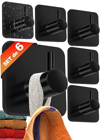 Six crochets noirs adhésifs en acier inoxydable fixés sur un mur clair de salle de bain